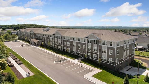 A large apartment complex with a parking lot in front.