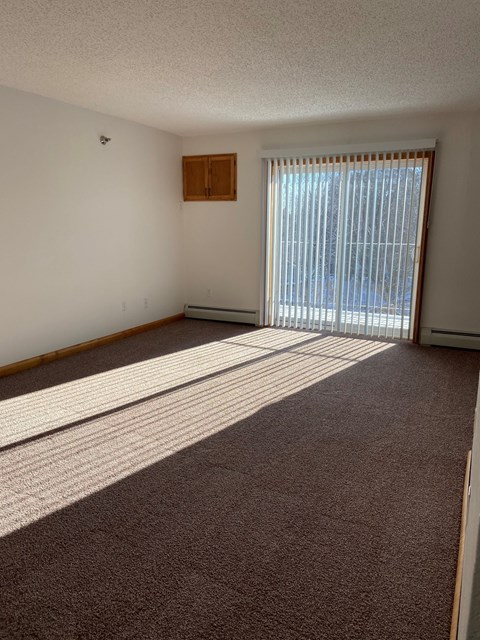 an empty living room with blinds on the window