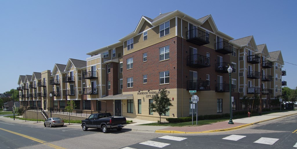 A large apartment building with a parking lot in front.