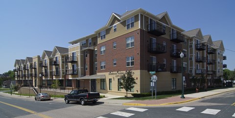 A large apartment building with a parking lot in front.