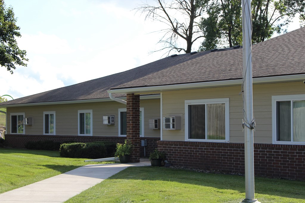 Mayer Elderly complex with a grey roof and a grey pole in front of it.