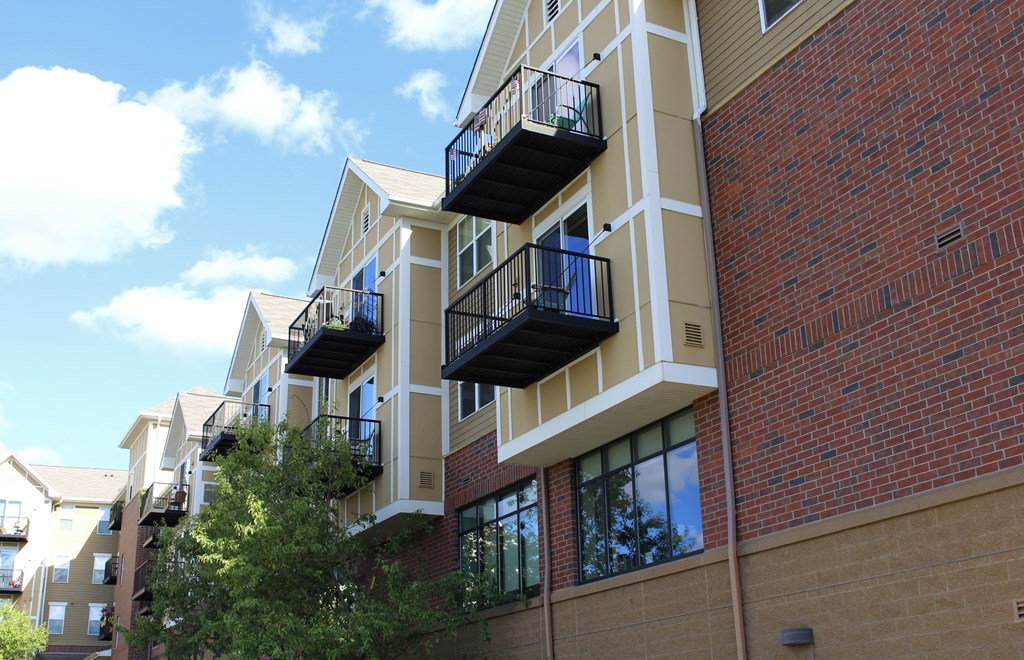 A building with balconies and a brick wall.