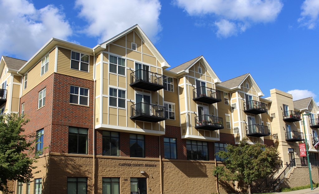 A large apartment building with balconies and a red brick facade.