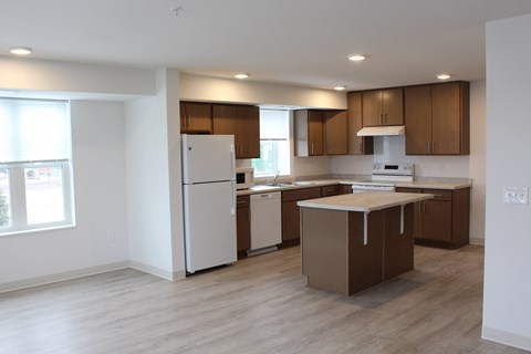 A kitchen with brown cabinets and a white fridge.