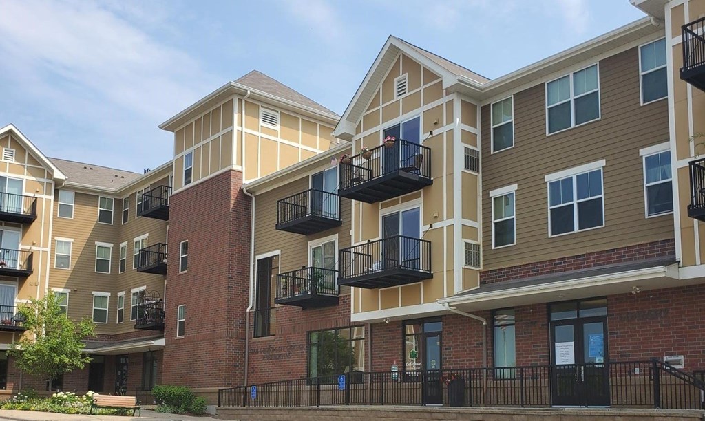 Apartment complex with balconies and a clear sky.