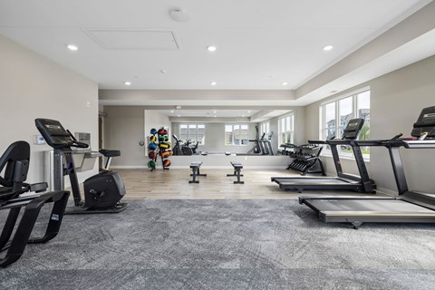 A spacious gym with treadmills, elliptical machines, and other exercise equipment.