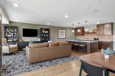 A modern living room with a brown sofa and a wooden dining table.