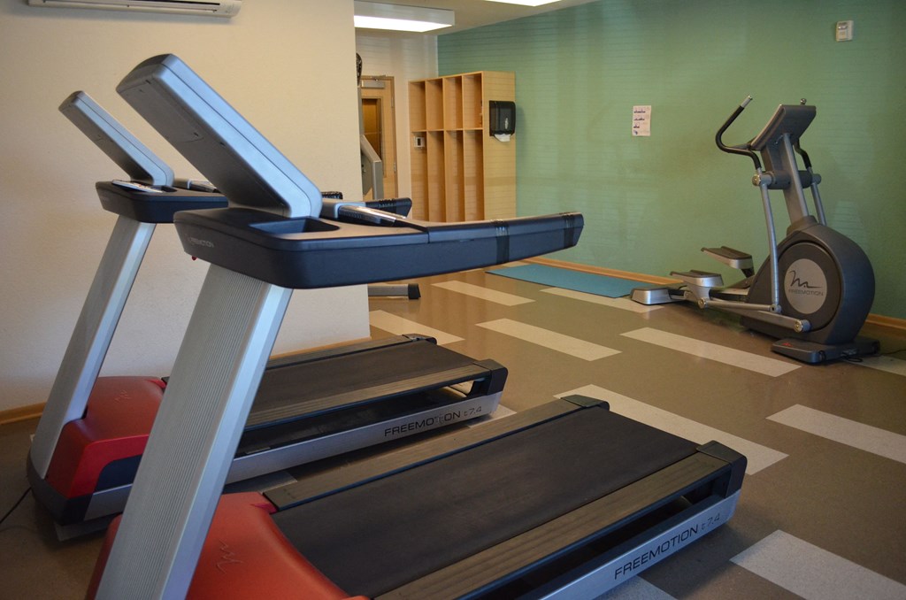 a gym with treadmills and weights in a health room