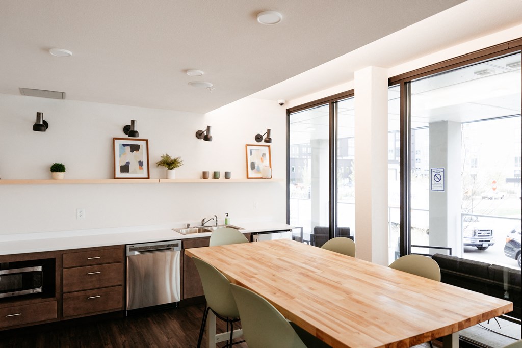 Community Room including a table, chairs, and kitchen next to large windows