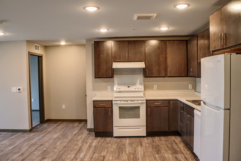 a kitchen with dark wood cabinets and white appliances