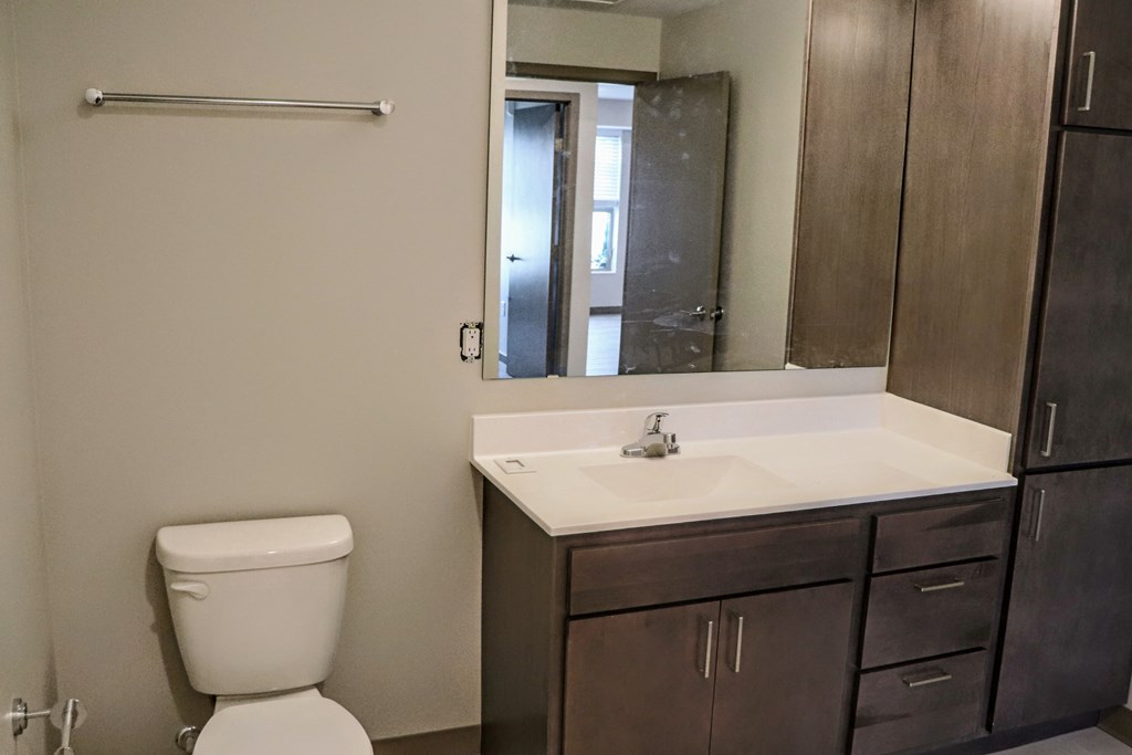 a bathroom with a toilet sink and mirror