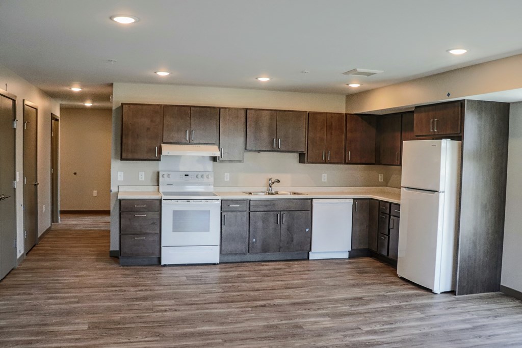 a kitchen with white appliances and dark wood cabinets