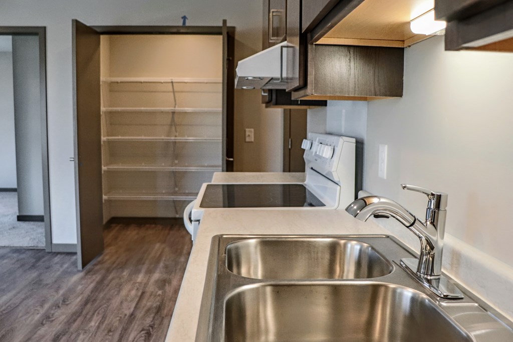 a kitchen with a sink and a glasstop stove