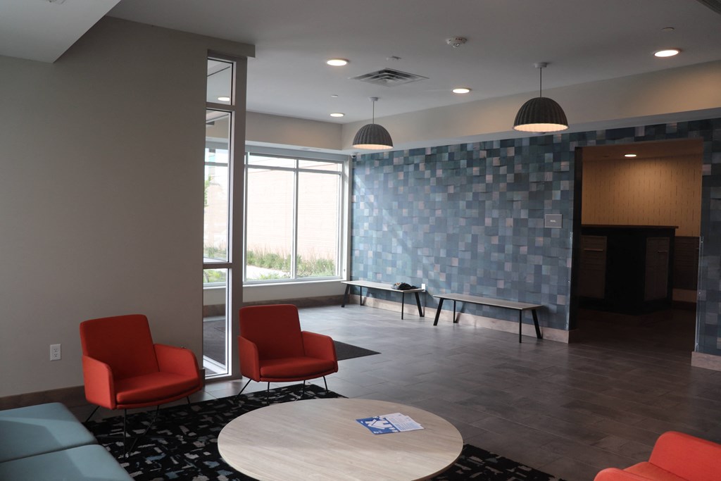a room with chairs and a table and a blue tile wall