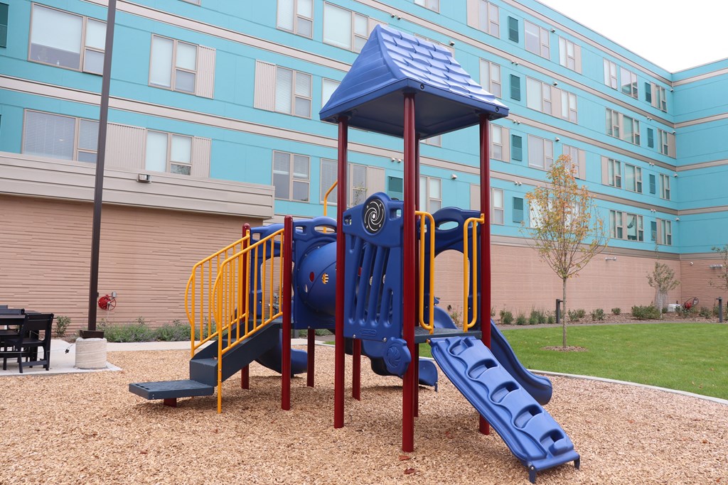 a playground at an apartment building with a blue playset
