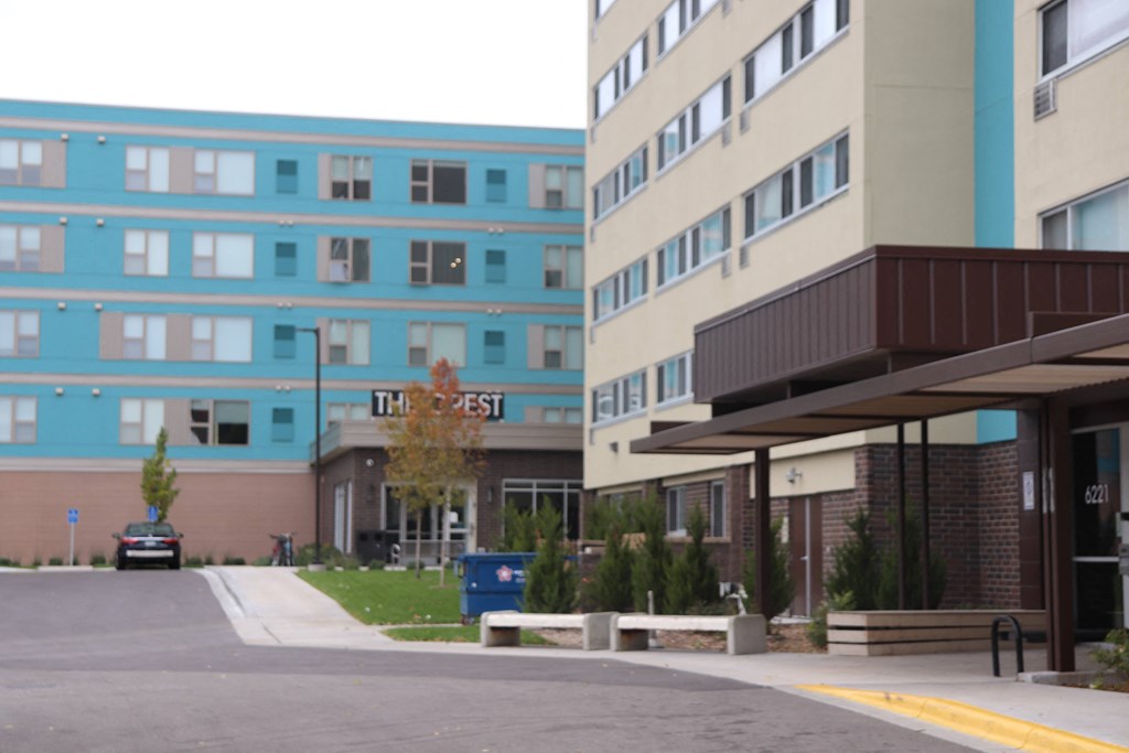 a view of the outside of an apartment building and a parking lot