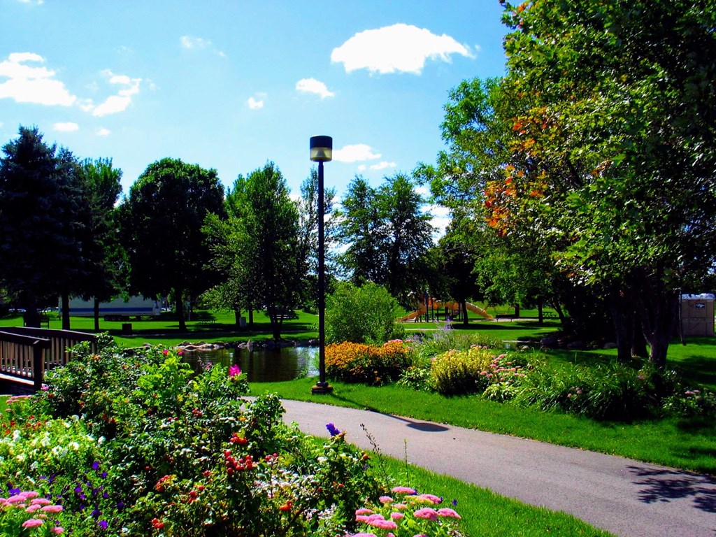 a path through a park with flowers and trees
