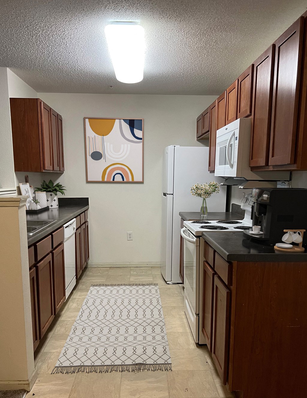 a kitchen with a white refrigerator freezer next to a stove top oven