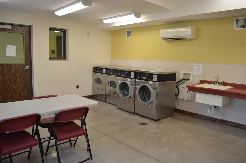 a laundry room with two washing machines and a table with chairs
