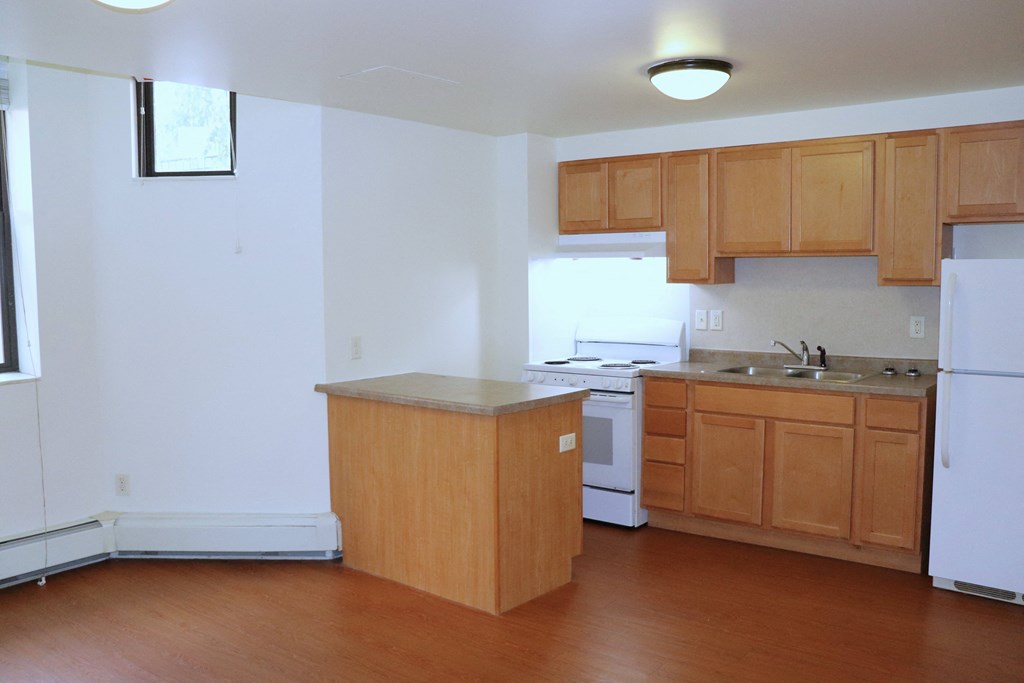 an empty kitchen with an island in the middle of it
