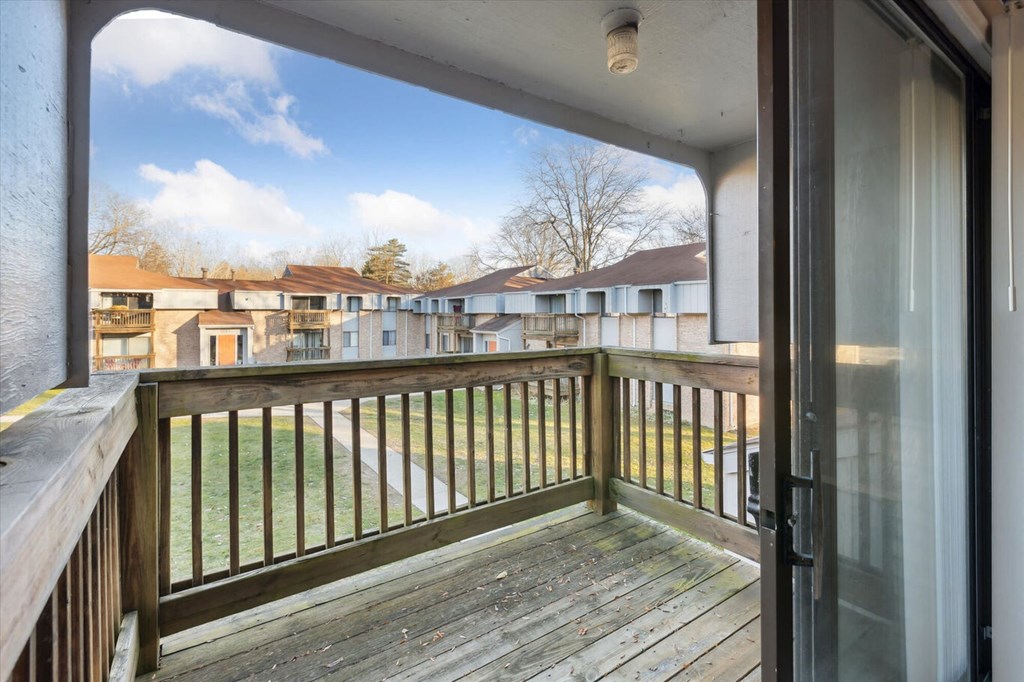 the balcony has a view of the yard and the house