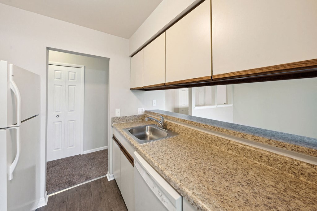 a kitchen with granite counter tops and a stainless steel sink