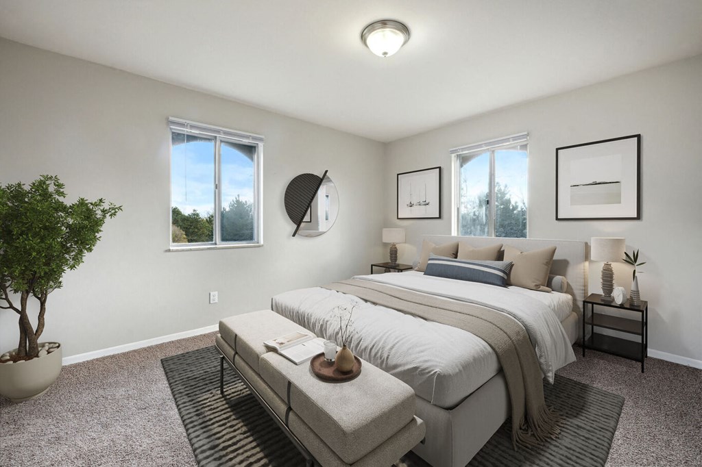 an empty bedroom with a bed and two windows