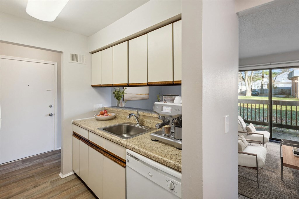 a kitchen with white cabinets and a sink and a window