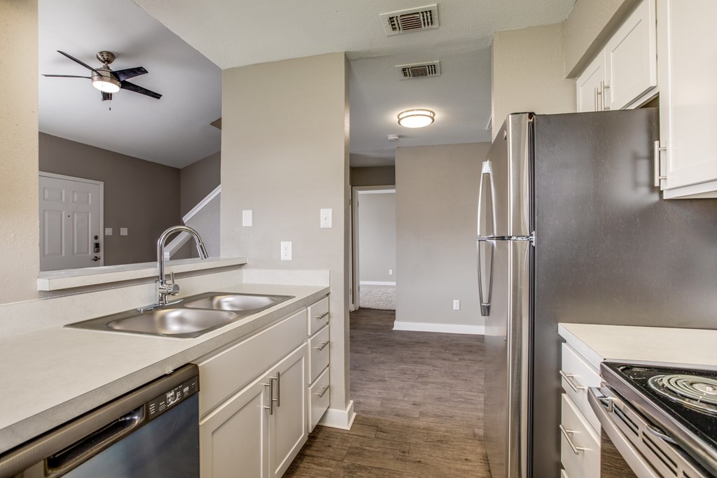 A modern kitchen with a stainless steel refrigerator and a dishwasher.