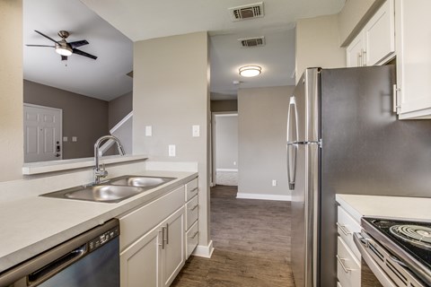 A modern kitchen with a stainless steel refrigerator and a dishwasher.