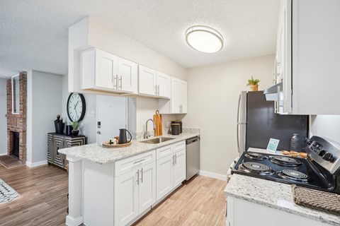 an open kitchen with white cabinets and a black stove and refrigerator