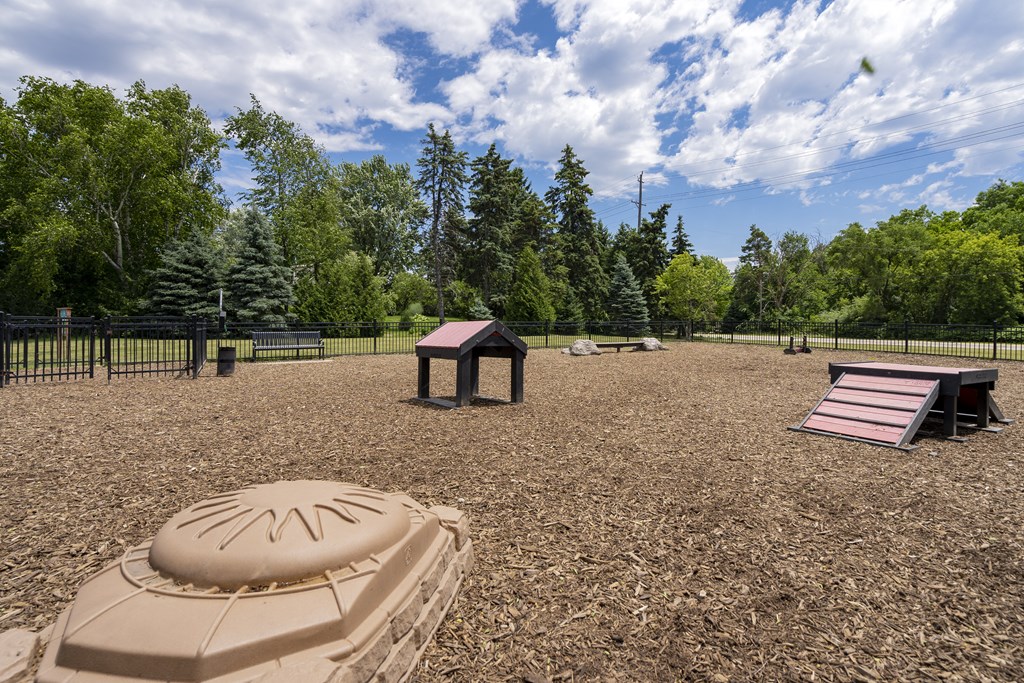a playground with a sandbox and a picnic table in a park