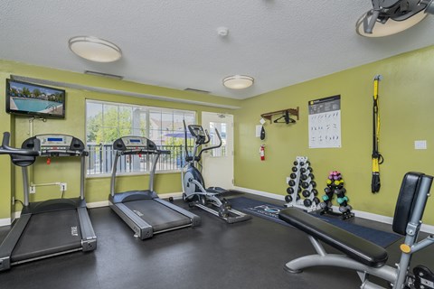 a gym with treadmills and other exercise equipment and windows