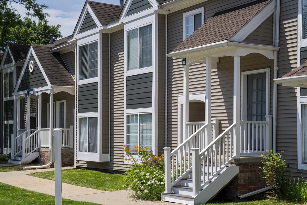 a row of suburban homes with stairs and porch