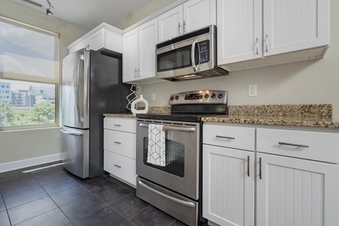 a kitchen with white cabinets and stainless steel appliances