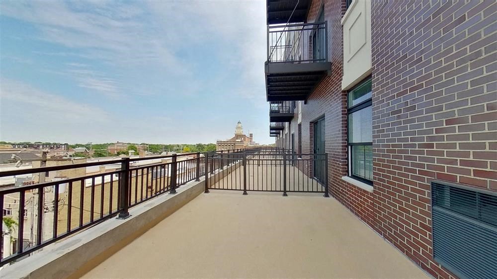 a balcony with a view of a city and a brick building