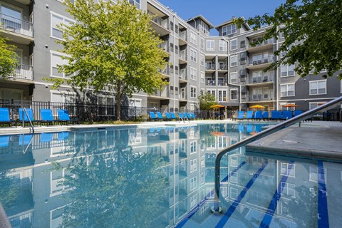 A large pool in front of apartment buildings.