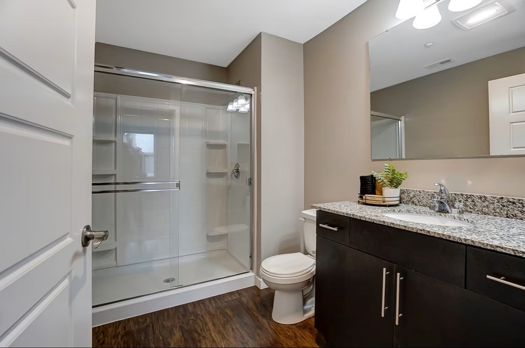 A bathroom with a toilet, sink, and shower.