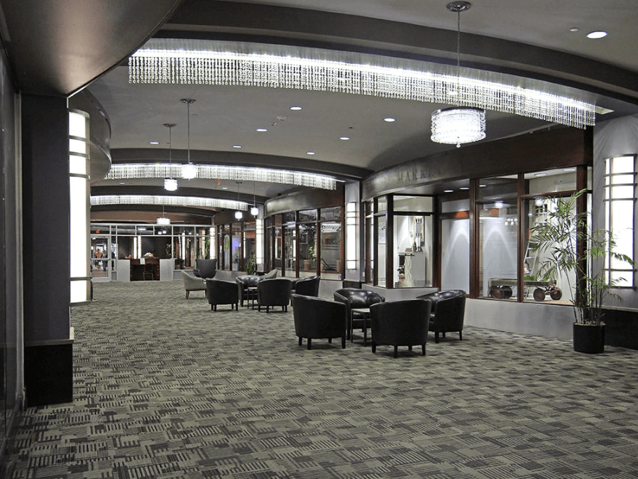 A large room with a carpeted floor and a long table with chairs.