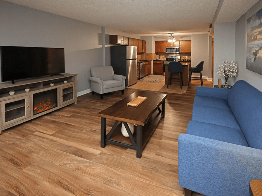 A living room with a blue couch and a wooden coffee table.