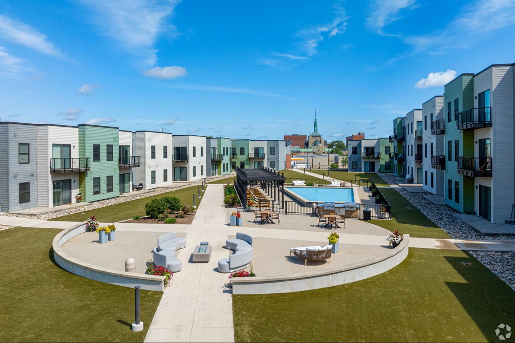 A sunny day at a residential complex with a pool and a playground.