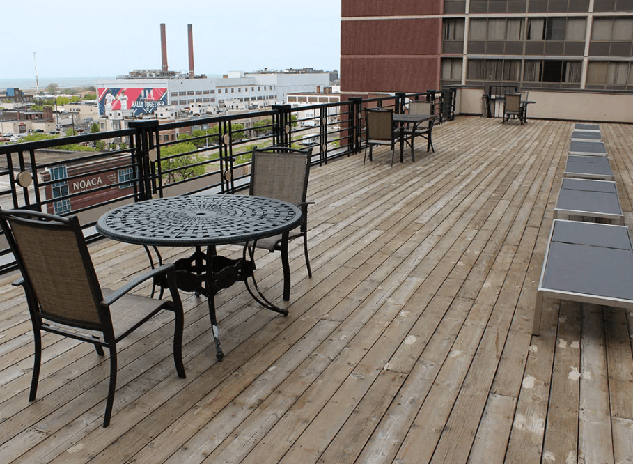 A wooden deck with a table and chairs overlooking a cityscape.