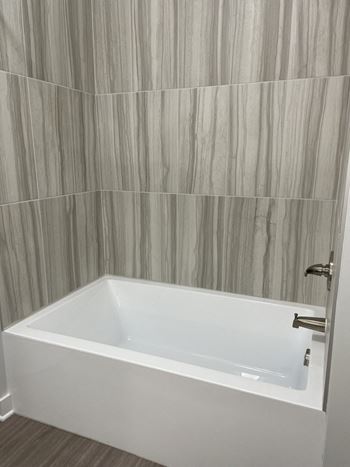 a white bath tub in a bathroom with a shower curtain