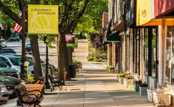 a sidewalk with benches and shops on a city street