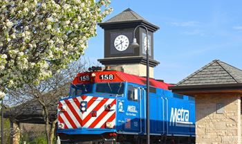 a train is parked in front of a clock tower
