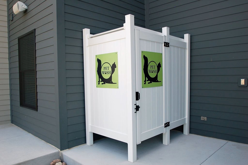 A white gate with two signs on it that say pet waste.