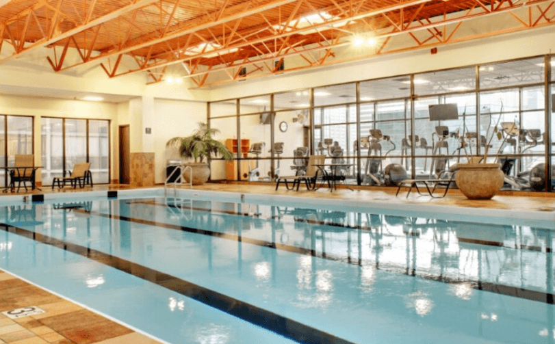 A large indoor swimming pool with a glass wall on one side.