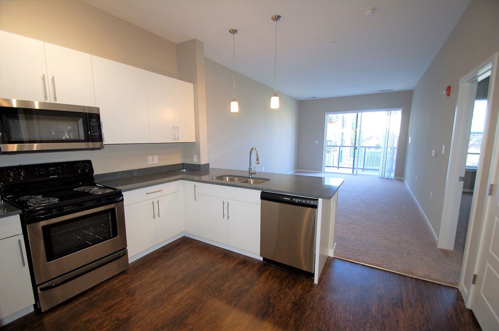 A kitchen with white cabinets and a black stove top oven.