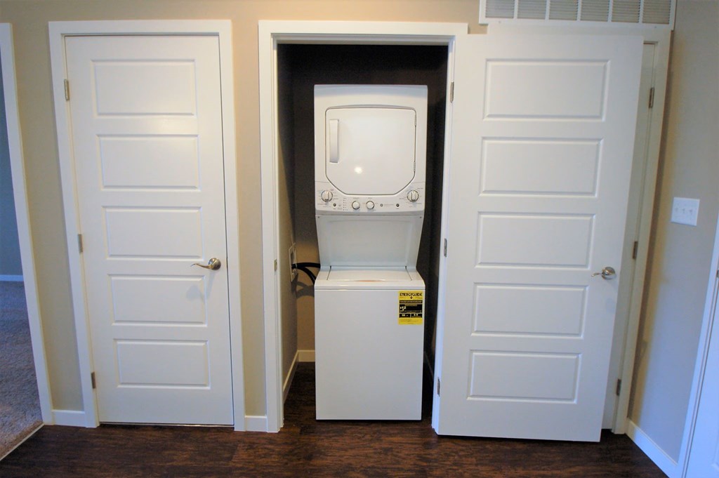 A white oven is in a small space between two doors.