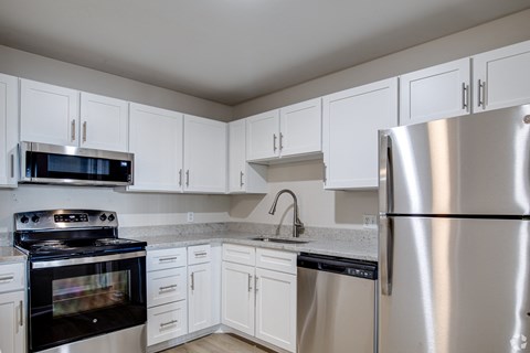 A kitchen with white cabinets and stainless steel appliances.